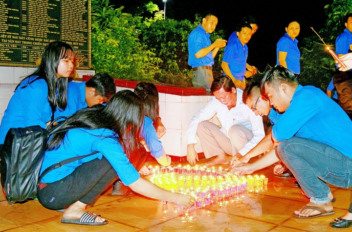 Đồng chí Hồ Văn Huân- Ủy viên Thường vụ Tỉnh ủy, Bí thư Thành ủy Vĩnh Long (áo trắng) cùng ngồi thắp nến tri ân với các đoàn viên thanh niên.