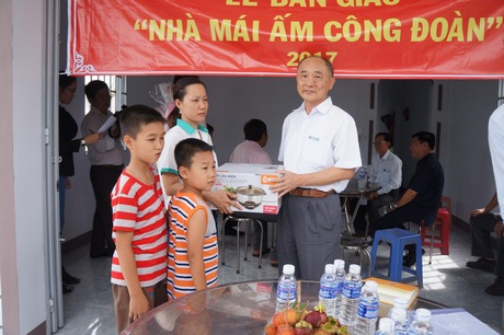 Tổng Giám đốc Công ty TNHH Tỷ Xuân- Trần Triều Kang tặng quà cho chị Ngọc Bích trong ngày bàn giao “Mái ấm Công đoàn”