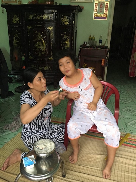 Nụ cười hiếm hoi của con gái bị nhiễm chất độc da cam cũng làm ấm lòng trái tim người mẹ của chị Kim Phương.