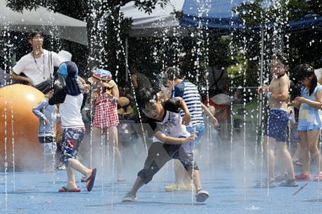 Trẻ em chơi đùa dưới vòi phun nước để tránh nắng nóng tại Tokyo, Nhật Bản ngày 9/8. (Nguồn: EPA/TTXVN)