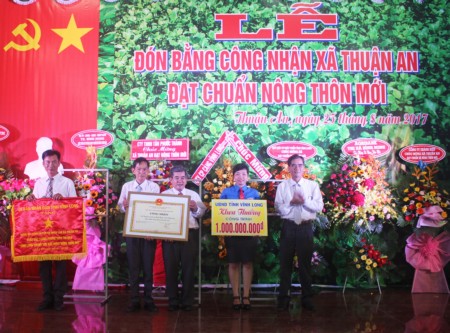 Ông Lê Quang Trung- Ủy viên Thường vụ Tỉnh ủy, Phó Chủ tịch thường trực UBND tỉnh trao bằng công nhận đạt chuẩn nông thôn mới và khen thưởng công trình phúc lợi trị giá 1 tỷ đồng cho xã Thuận An.