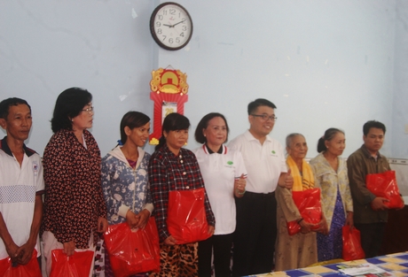 Ông Wang Peng Yao (thứ tư từ phải sang)- Trưởng chi nhánh tại Vĩnh Long- trao quà cho bà con nghèo.
