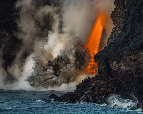 Nóng và lạnh. (Nguồn: NatGeo). Tác giả đã chớp được khoảnh khắc dòng nham thạch từ núi lửa Kīlauea ở hòn đảo Hawai chảy xuống đại dương. Khi dung nham nóng chảy vào vùng nước mát, những mảnh đá nổ tung.