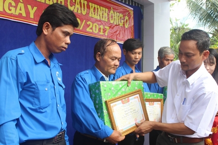 Ông Phan Thanh Tùng- Phó Chủ tịch UBND xã trao giấy khen và quà cho các cá nhân, tập thể tích cực đóng góp ngày công xây dựng cầu.