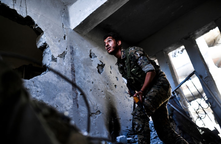 Khuôn mặt đầy căng thẳng của một tay súng SDF khi tiến vào lục soát bên trong một ngôi nhà. Ảnh: AFP.