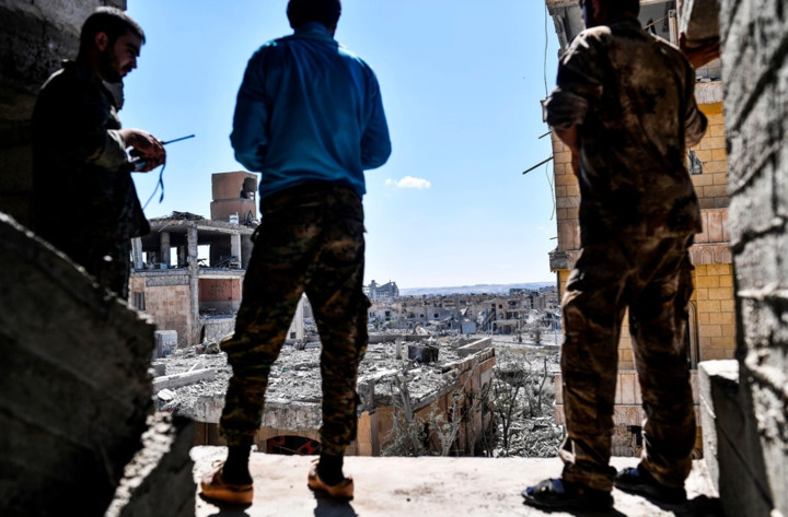 Những thành viên SDF thảnh thơi đứng quan sát khu vực gần bệnh viện trung tâm ở Raqqa khi tình hình chiến sự tạm yên ắng. Ảnh: AFP.