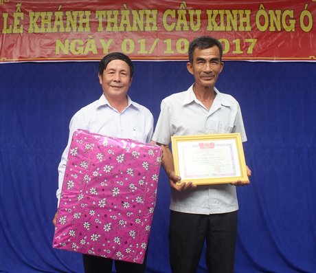 Ông Nguyễn Hoàng Nam (phải) được nhận giấy khen của UBND thị xã vì tích cực hiến đất và ngày công xây cầu.