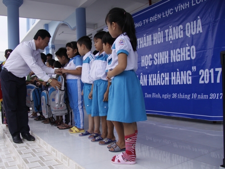 Ông Huỳnh Vĩnh Phúc- Chánh văn phòng Công ty Điện lực Vĩnh Long tặng quà cho học sinh Trường Tiểu học Cái Ngang.
