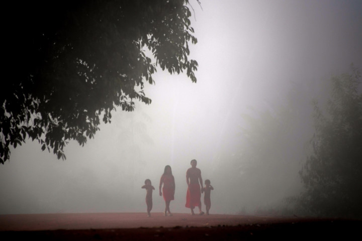 Một gia đình người Waiapi bước đi trong sương sớm./.