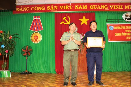 Đại diện lãnh đạo Phòng Xây dựng phong trào Toàn dân bảo vệ an ninh Tổ quốc- Công an tỉnh trao bằng khen cho anh Nguyễn Minh Chiến.