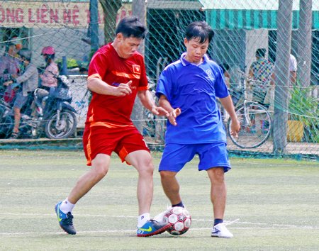 Pha tranh bóng giữa Trường THPT chuyên Nguyễn Bỉnh Khiêm (áo xanh) trận chung kết thắng Công ty Bảo Việt 2-0.