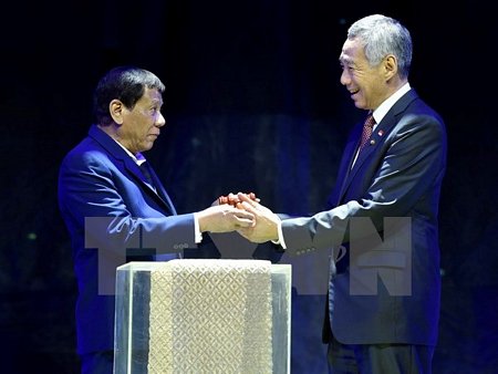 Thủ tướng Singapore Lý Hiển Long (phải) nhận biểu tượng tại lễ chuyển giao chức Chủ tịch luân phiên ASEAN từ Tổng thống Philippines Rodrigo Duterte tại Manila ngày 14/11. (Nguồn: THX/TTXVN)