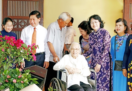 Các vị lãnh đạo cùng chụp ảnh lưu niệm với bà Ngô Thị Huệ tại Khu tưởng niệm cố Thủ tướng Võ Văn Kiệt.
