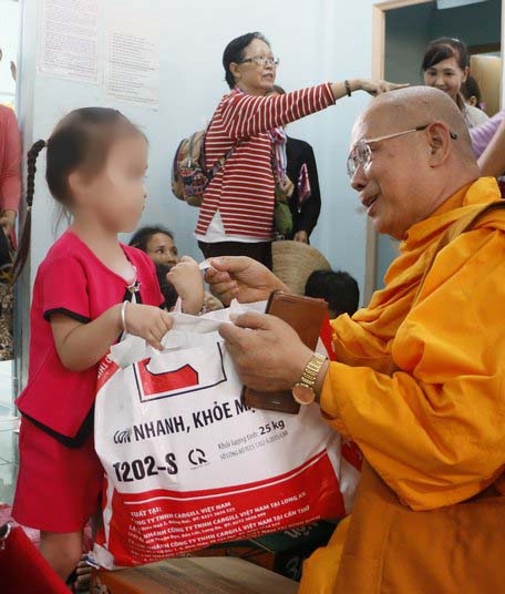 Thượng tọa Thích Giác Hiển- Phó Ban Phật giáo tỉnh Vĩnh Long trao quà và động viên trẻ em là nạn nhân chất độc da cam 