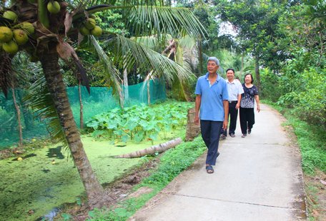 Ông Lê Văn So đang đi trên con đường đan mà chính ông đã từng hiến đất để thi công. Nay, chuẩn bị thực hiện con đường mới cũng có sự đồng tình ủng hộ của gia đình ông.