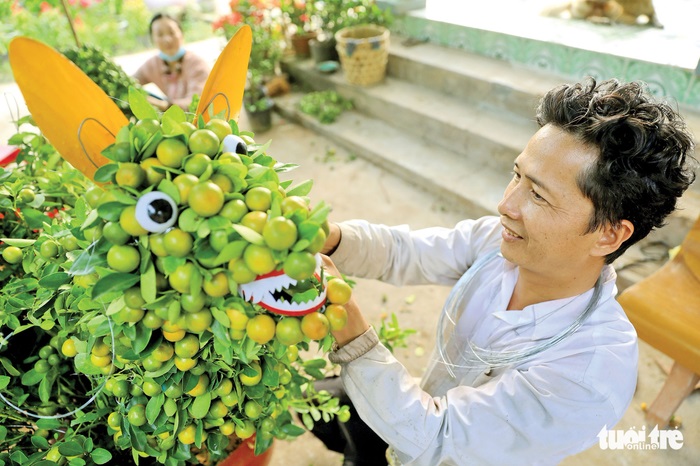 Ông Lê Văn Trí (huyện Chợ Lách, Bến Tre) cho biết để tạo hình một con chó từ những cây tắc phải mất 5 - 7 ngày - Ảnh: HỮU KHOA