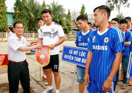 Ông Nguyễn Văn Bé Tư- Phó Ban Tuyên giáo Tỉnh uỷ trao cờ lưu niệm cho các đội bóng tham dự giải tại lễ khai mạc.