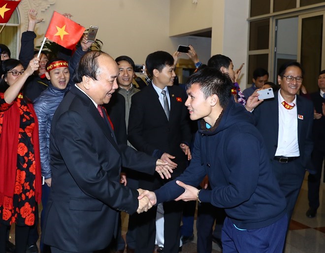 Thủ tướng Nguyễn Xuân Phúc chúc mừng cầu thủ Quang Hải. (Ảnh: Thống Nhất/TTXVN)