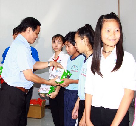 Ông Phạm Hoàng Khải -Tổng biên tập Báo Vĩnh Long trao quà cho các em học sinh có hoàn cảnh khó khăn.
