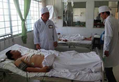 Giám đốc Bệnh viện Đa khoa tỉnh Vĩnh Long- bác sĩ chuyên khoa II Văn Công Minh (bên trái) thăm hỏi bệnh nhân bị đâm thủng tim.