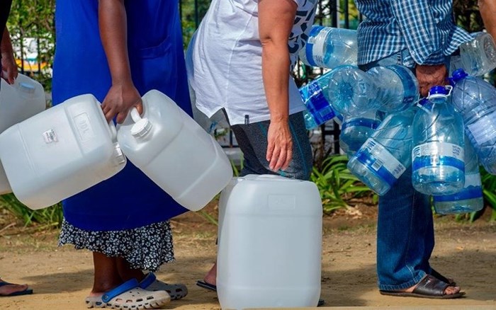 Hình ảnh người dân Nam Phi lủng củng các bình nhựa lớn nhỏ xếp hàng lấy nước.