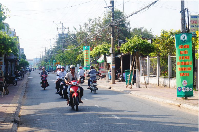 Đường phố từ thành thị đến nông thôn đã trở nên nhộn nhịp hơn, tươi vui hơn với cờ hoa, băng rôn, khẩu hiệu (Trong ảnh: Đường phố ở thị trấn Tam Bình)
