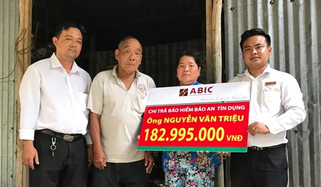 Ông Võ Văn Hoàng- đại diện ABIC (phải) và ông Đặng Duy An- đại diện Agribank PGD Bình Phước (trái) trao biểu trưng cho khách hàng.