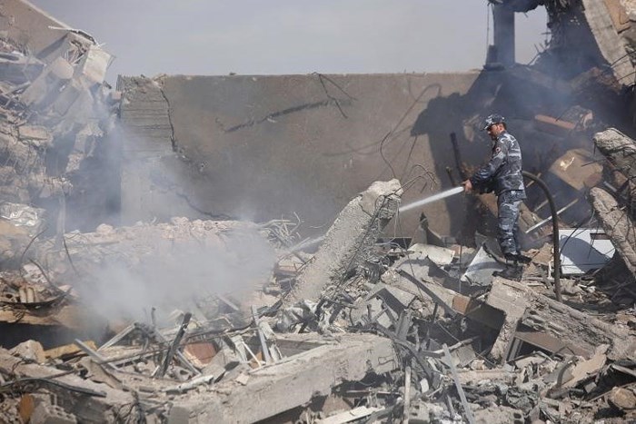 Một lính cứu hỏa Syria ở bên trong Trung tâm Nghiên cứu Khoa học ở Damascus, Syria, đã trở thành đống đổ nát sau cuộc tấn công nói trên. Ảnh: Reuters.