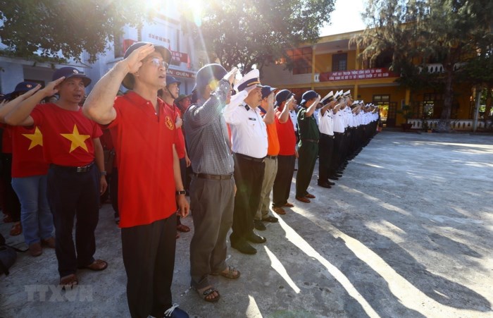 Đại biểu đoàn công tác số 5 dự Lễ chào cờ trên đảo Sinh Tồn. (Ảnh: Minh Quyết/TTXVN)