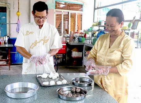  Cô Trần Ngọc Hiệp (ảnh, phải) đang làm món bánh khoai môn. Ảnh: ÁI LAM