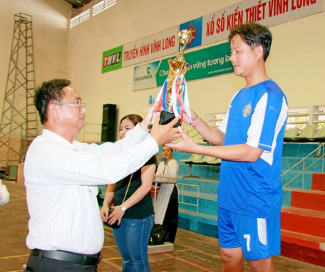 Ông Văn Hữu Huệ- Phó Giám đốc Sở Kế hoạch- Đầu tư trao chiếc cúp vô địch cho đội bóng đá Hội Doanh nhân trẻ.