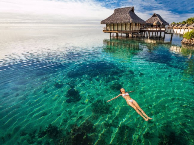 Nữ du khách thư giãn trong làn nước trong như ngọc tại đảo Moorea, Tahiti.
