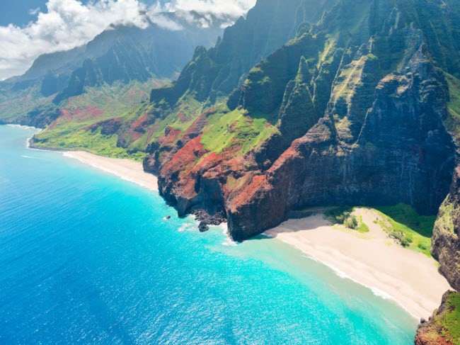 Song biển đánh vào dãy núi hùng vĩ trên đảo Kauai, Hawaii.