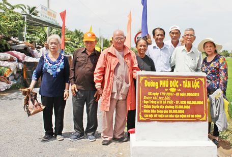 Bà Huỳnh Thị Sương (thứ 4, bên trái) đã góp công rất lớn trong việc vận động và xây dựng tuyến đường liên xã Phú Đức- Tân Lộc.
