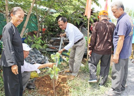 Đồng chí Trương Văn Hưng- Bí thư Đảng ủy xã (giữa)- trồng cây bồ đề (do nhà tài trợ trao tặng) trước tuyến đường.