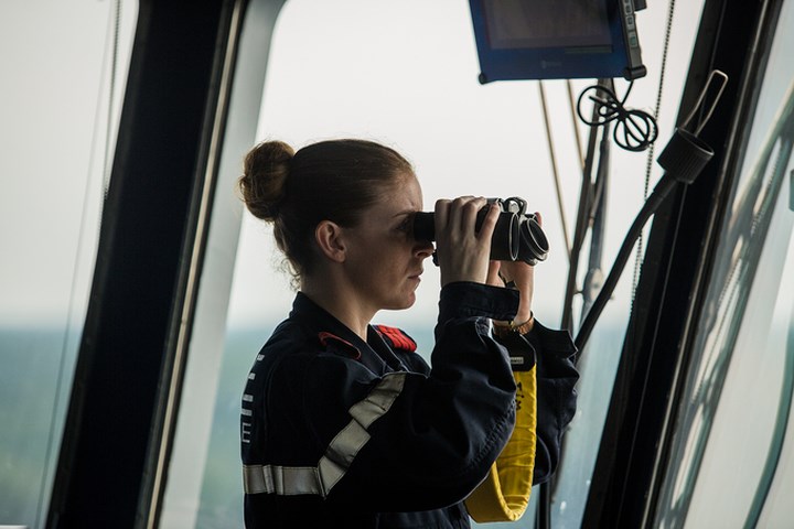 Nữ sĩ quan tàu Dixmude dùng ống nhòm quan sát các vật thể di chuyển quanh tàu. 