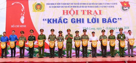 Đại tá Huỳnh Thanh Mộng- Phó Giám đốc Công an tỉnh trao cờ lưu niệm cho các đơn vị tham gia hội trại