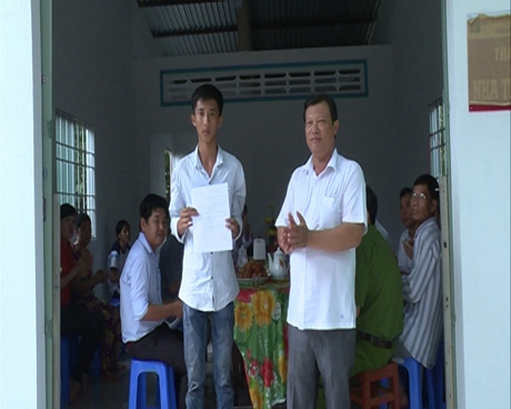 Lãnh đạo địa phương trao quyết định bàn giao nhà tình thương cho em Nguyễn Thanh Nguyên mồ côi cha lẫn mẹ.