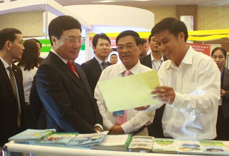 Phó Thủ tướng Phạm Bình Minh (bên trái) và Phó Chủ tịch UBND tỉnh Vĩnh Long- Trần Hoàng Tựu (áo trắng, giữa) tại gian hàng trưng bày triễn lãm của tỉnh Vĩnh Long.