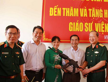 Thượng tướng Bế Xuân Trường (bìa phải) trao tặng hiện trưng bày cho đại diện lãnh đạo Sở Văn hóa, Thể thao và Du lịch.