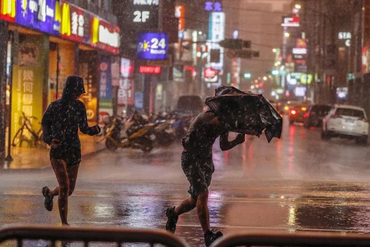 Người dân khổ sở vì mưa lớn gây ra bởi siêu bão Maria ở TP Đài Bắc vào ngày 10/7. Ảnh: EPA