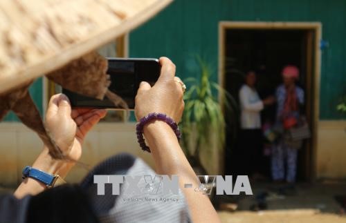 Du khách lưu giữ hình ảnh trên điện thoại những khoảnh khắc được trải nghiệm ở buôn làng K’Ho. Ảnh: Nguyễn Dũng/TTXVN