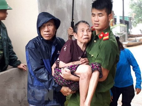 Lực lượng công an huyện Con Cuông giúp dân chuyển đến nơi an toàn. (Ảnh: Bá Hậu/TTXVN)