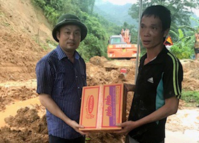 Ông Cao Văn Cường, Chủ tịch UBND huyện Mường Lát (người đội mũ cối) trao hàng cứu trợ cho bà con xã Trung Lý