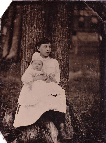 Cô gái ngồi bế một đứa trẻ với khuôn mặt trầm tư năm 1884.