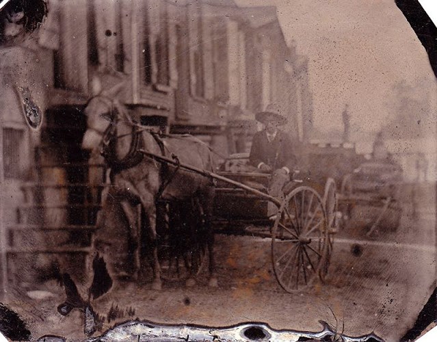 Những ngôi nhà và một người đánh xe trên đường phố được chụp vào cuối thế kỷ 19.