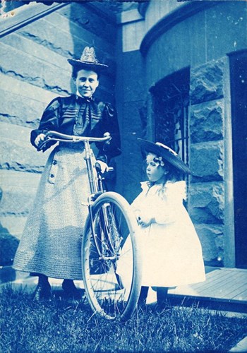 Người phụ nữ và một bé gái xinh xắn chụp ảnh bên cạnh chiếc xe đạp năm 1895.