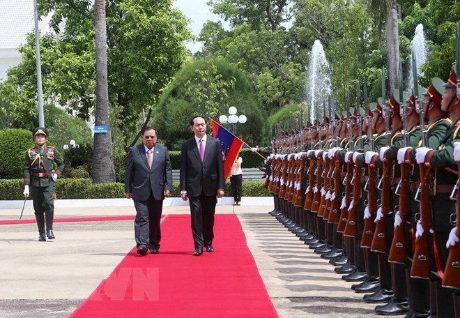 Chủ tịch nước Trần Đại Quang và Tổng Bí thư, Chủ tịch nước Lào Bounnhang Volachith duyệt Đội danh dự Quân đội Nhân dân Lào tại Lễ đón chính thức ở thủ đô Vientiane, sáng 12/6, Lào. (Ảnh: Nhan Sáng/TTXVN)