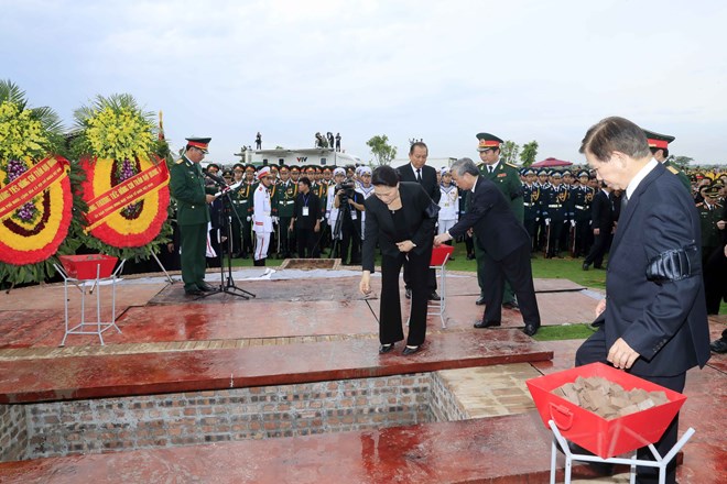  Chủ tịch Quốc hội Nguyễn Thị Kim Ngân và các đồng chí lãnh đạo, nguyên lãnh đạo Đảng, Nhà nước thả những nắm đất đầu tiên xuống huyệt mộ Chủ tịch nước Trần Đại Quang. (Ảnh: Nhan Sáng/TTXVN)