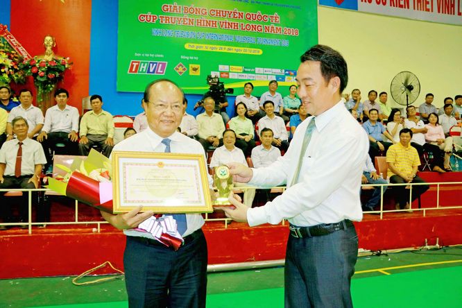 Phó Chủ tịch UBND tỉnh- Lữ Quang Ngời trao bằng khen, tặng phẩm của UBND tỉnh cho ông Lê Quang Nguyên- Giám đốc Đài PT- TH Vĩnh Long, nhà tài trợ chính mùa giải 2018.